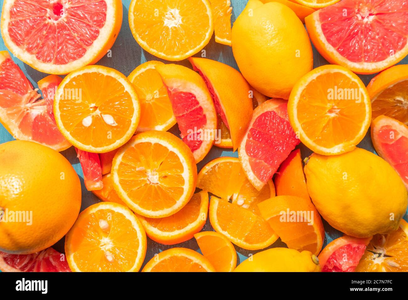 Frisch geschnittene Grapefruit und Orangenscheiben mit blauem Holzhintergrund. Stockfoto