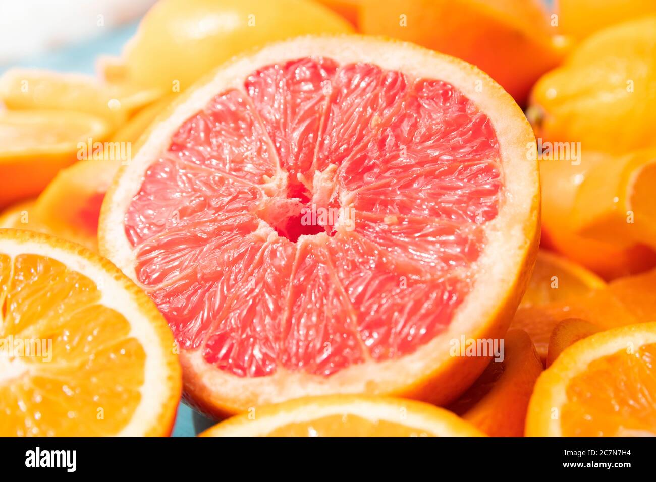 Frisch geschnittene Grapefruit und Orangenscheiben mit blauem Holzhintergrund. Stockfoto