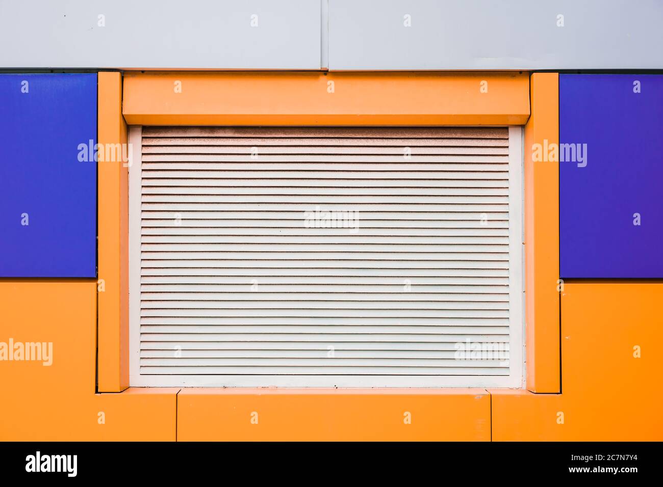 Modernes und farbenfrohes Gebäude mit weißen Jalousien Stockfoto