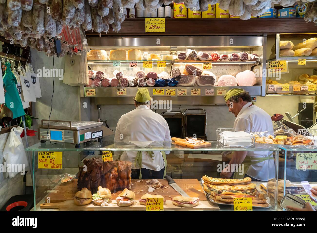 Rom/Italien - 09.10.2017; EIN typisch italienisches Feinkostgeschäft, in dem zwei Männer Sandwiches mit frischen Zutaten zubereiten. Spezialitäten werden angezeigt. Stockfoto