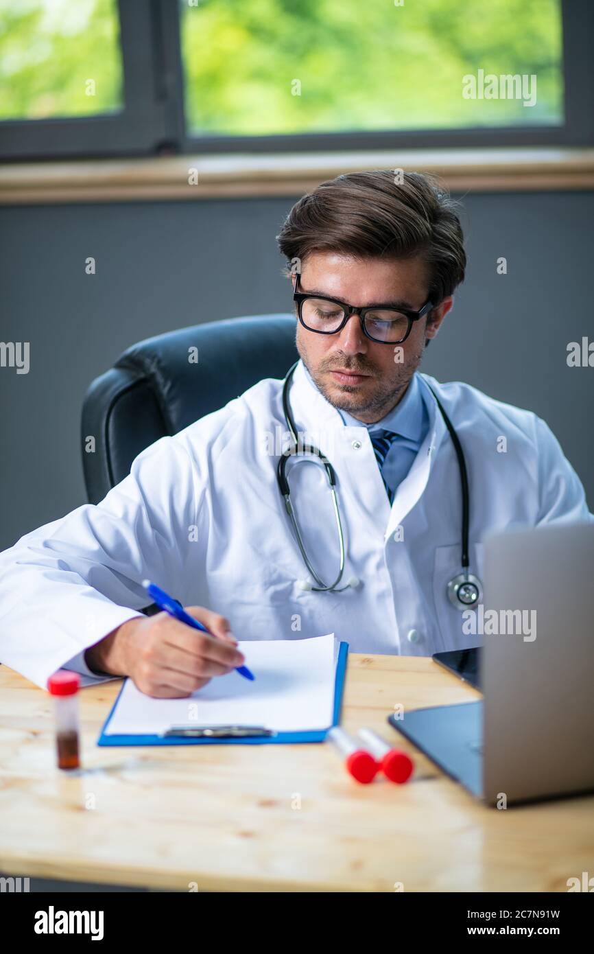 Fokussierter und besorgtem Arzt wring etwas o seine Notizen, Analyse eines Bluttests oder Probe, Suche nach einem Medikament für die Krankheit Stockfoto