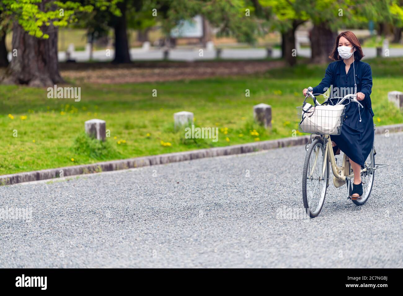 Kyoto, Japan - 17. April 2019: Japanische Frau auf dem Fahrrad Fahrrad auf der Straße ehrliches Stadtleben in Kyoto Gyoen trägt Maske Stockfoto