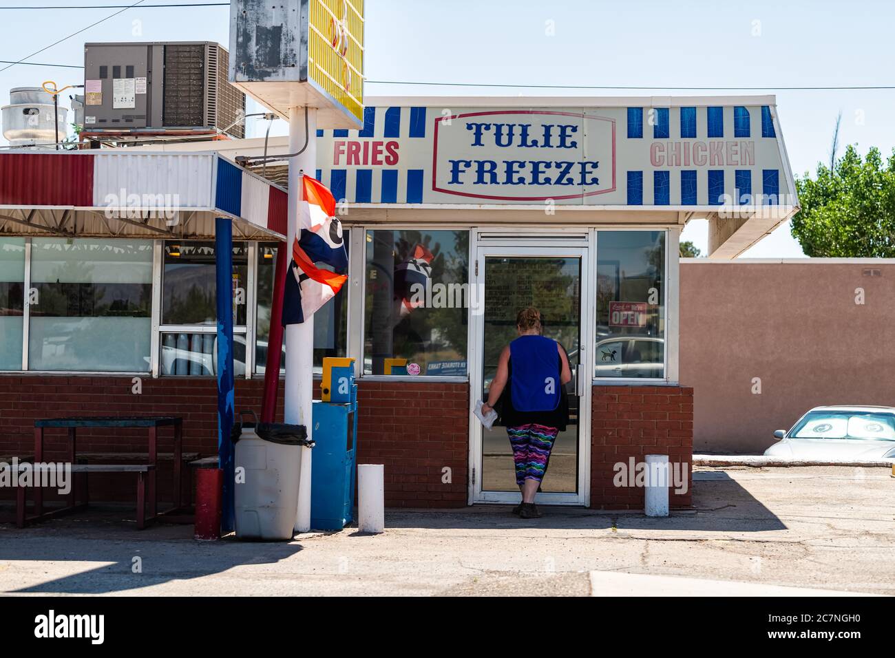 Tularosa, USA - 8. Juni 2019: New Mexico kleine Stadt-Straße mit Ladengeschäft Gebäude und lokale Frau beim Betreten Restaurant mit Schild für Tulie Freez Stockfoto