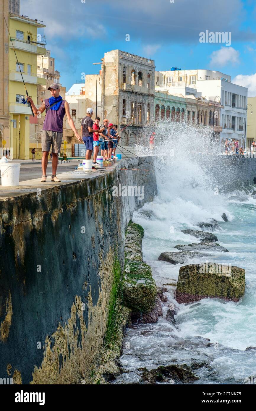 Fischer an der berühmten Malecon-Ufermauer in Havanna mit Wellen, die an der Wand krachen Stockfoto