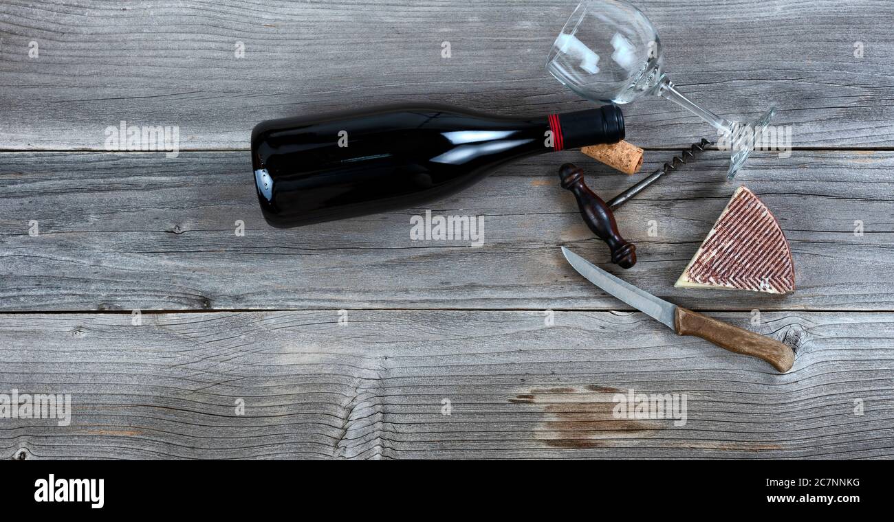 Frischer Käsekeil und Rotwein auf rustikalem Holz Stockfoto