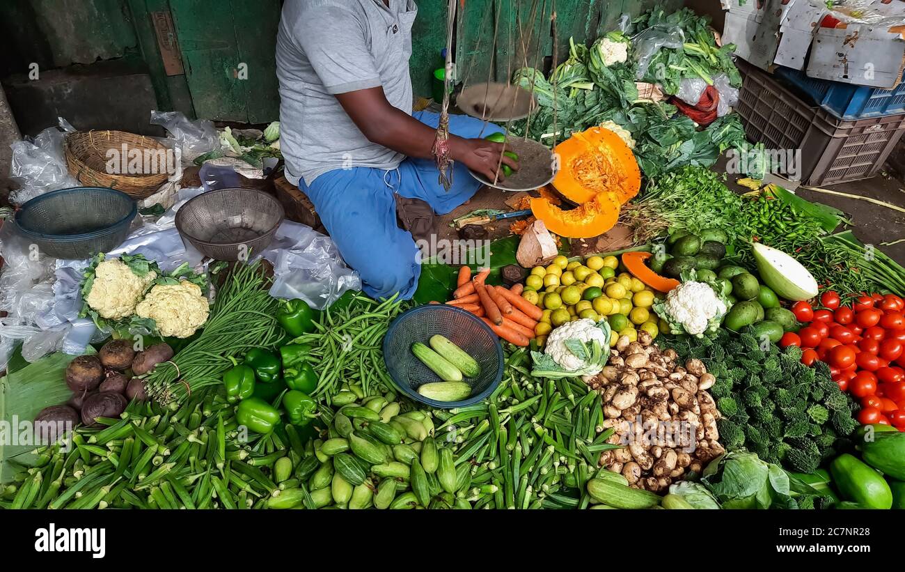 Frisches grünes Gemüse auf dem Display zum Verkauf mit Blick auf Der Ladenbesitzer in einem lokalen Markt in Kalkutta Indien Stockfoto