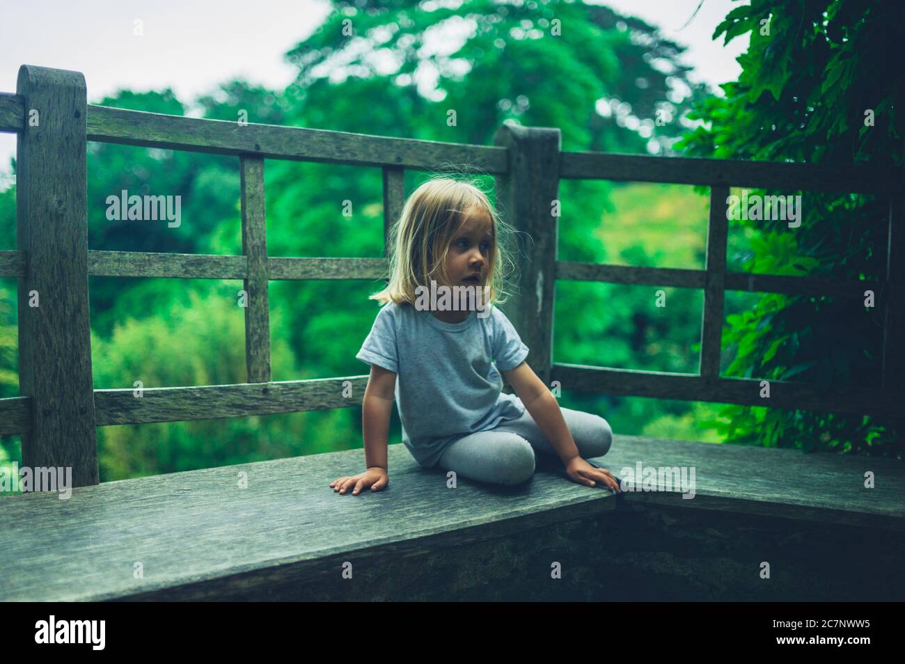 Ein kleiner Vorschuljunge ruht in einem Garten Stockfoto