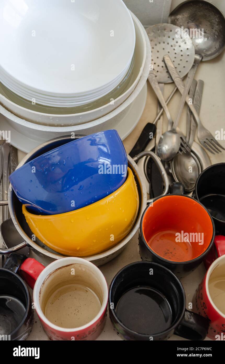 Dreckiges Geschirr in einem Keramikwaschbecken. Ungewaschene Teller, Tassen und Besteck. Draufsicht. Nahaufnahme Stockfoto