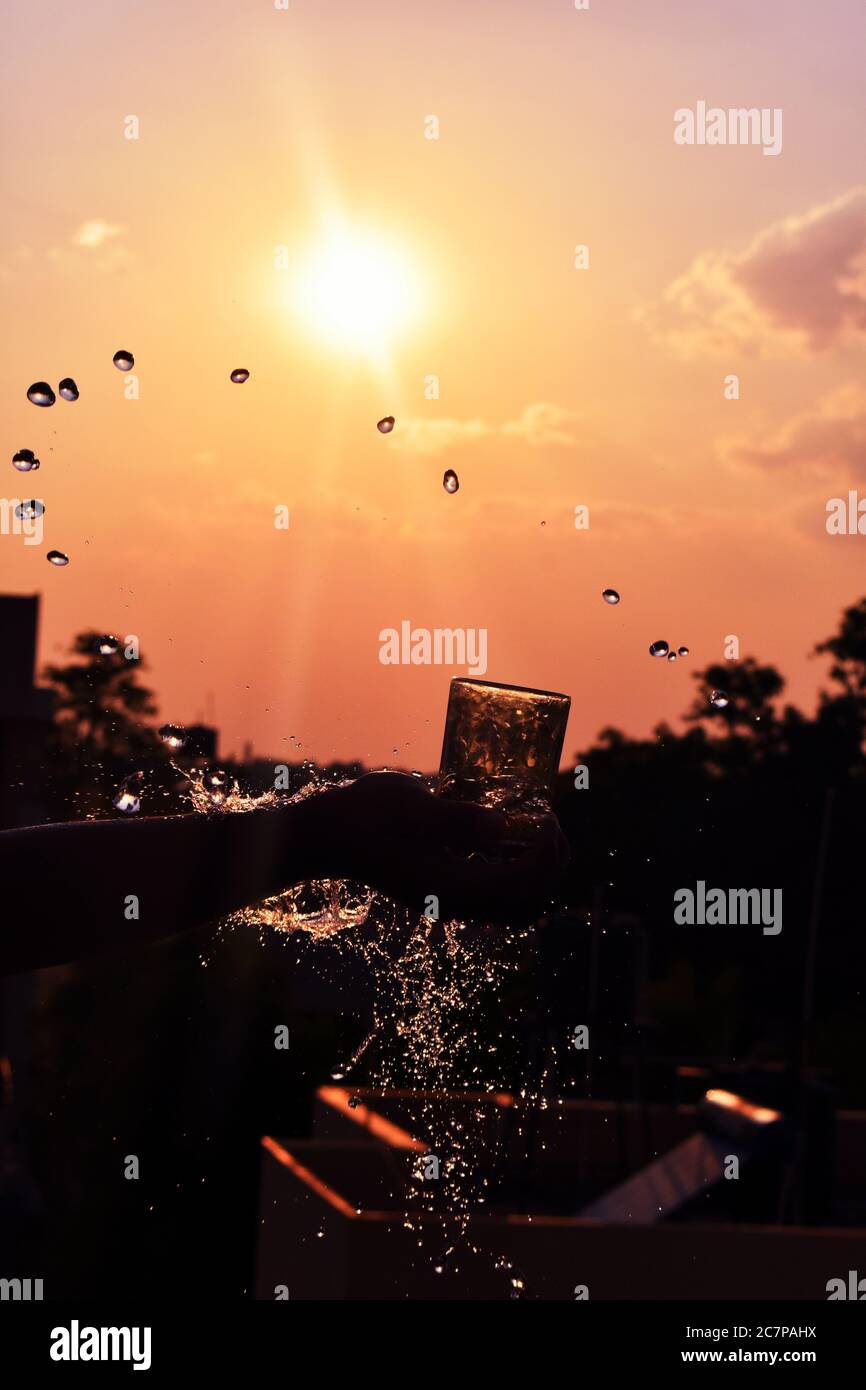 Wasserspritzer Bild von Wasser aus einem Glas in Abenduntergang geworfen Stockfoto