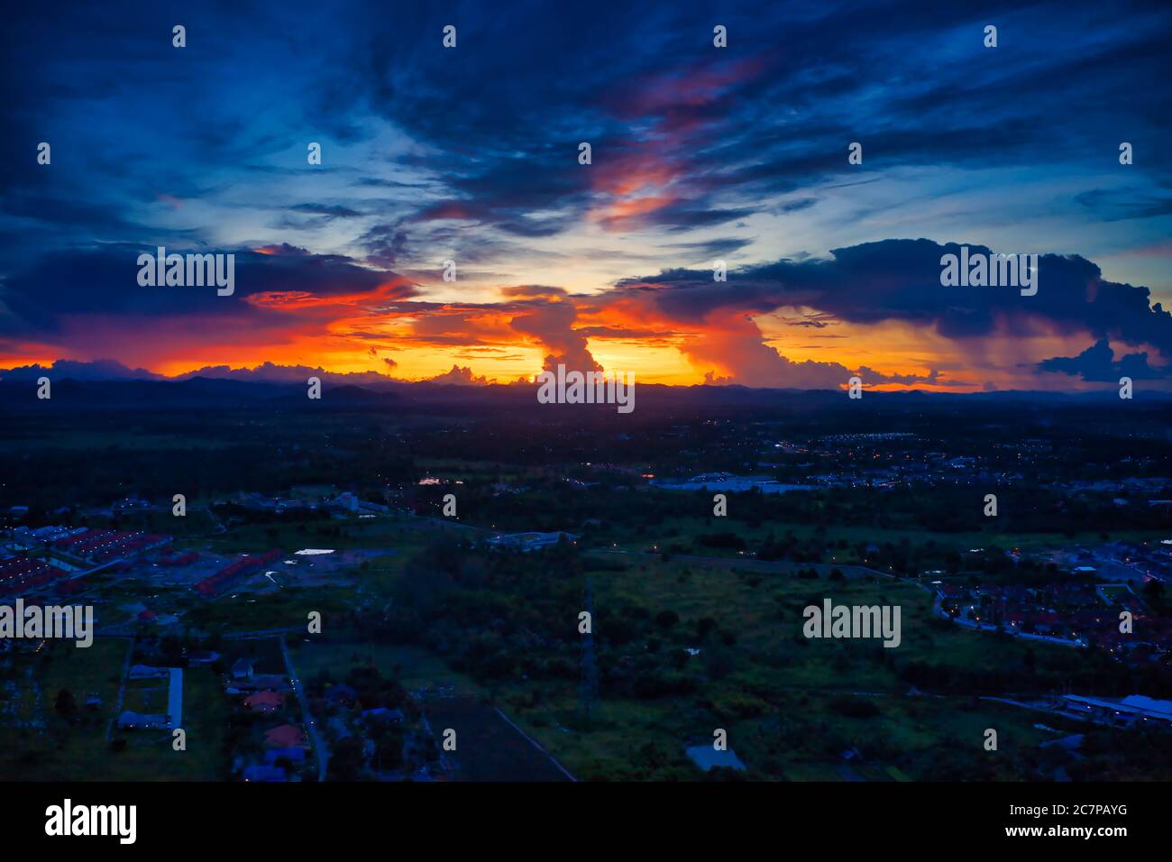 Dieses einzigartige Foto zeigt die Hinterlandschaft von Hua hin in Thailand bei einem Sonnenuntergang mit einem tollen Himmel. Sie können auch eine Bergkette im Hintergrund sehen. Stockfoto