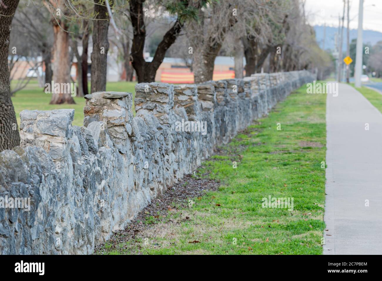Teil eines langen, von Anwohnern gebauten, niedrigen Steinzauns, der zwei Grenzen des Lawson Park in Mudgee, New South Wales, Australien, umgibt Stockfoto