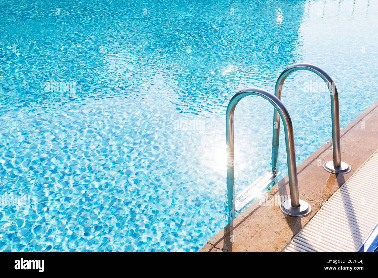 Blauer Swimmingpool mit Treppe im Luxushotel Stockfoto