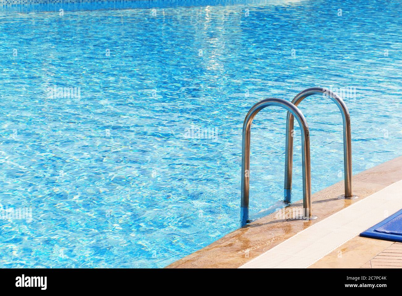 Blauer Swimmingpool mit Treppe im Luxushotel Stockfoto