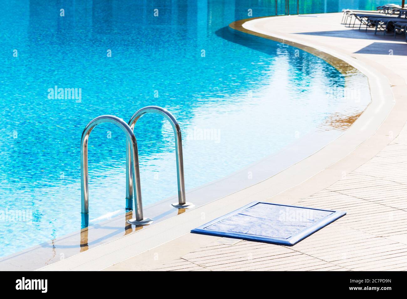 Blauer Swimmingpool mit Treppe im Luxushotel Stockfoto