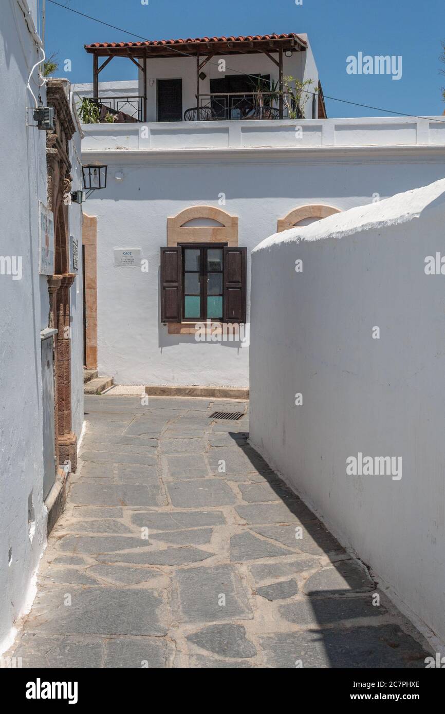 Schmale Straße mit weißen Mauern in der Stadt lindos auf der Insel rodos in griechenland. Stockfoto