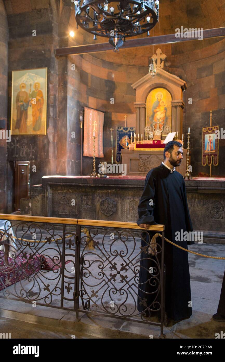 Touristen und Besucher werden Führungen durch das Innere von St. Astvatsatsin in Khor Virap gegeben, während Priester über ihre tägliche Arbeit gehen. Armenien Stockfoto