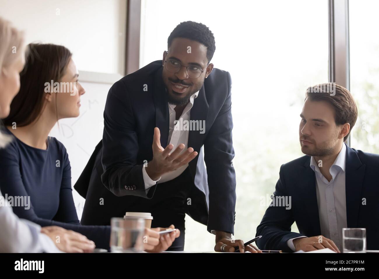Afrikanischer Mentor gibt den Mitarbeitern während des Treffens wertvolle Ratschläge Stockfoto