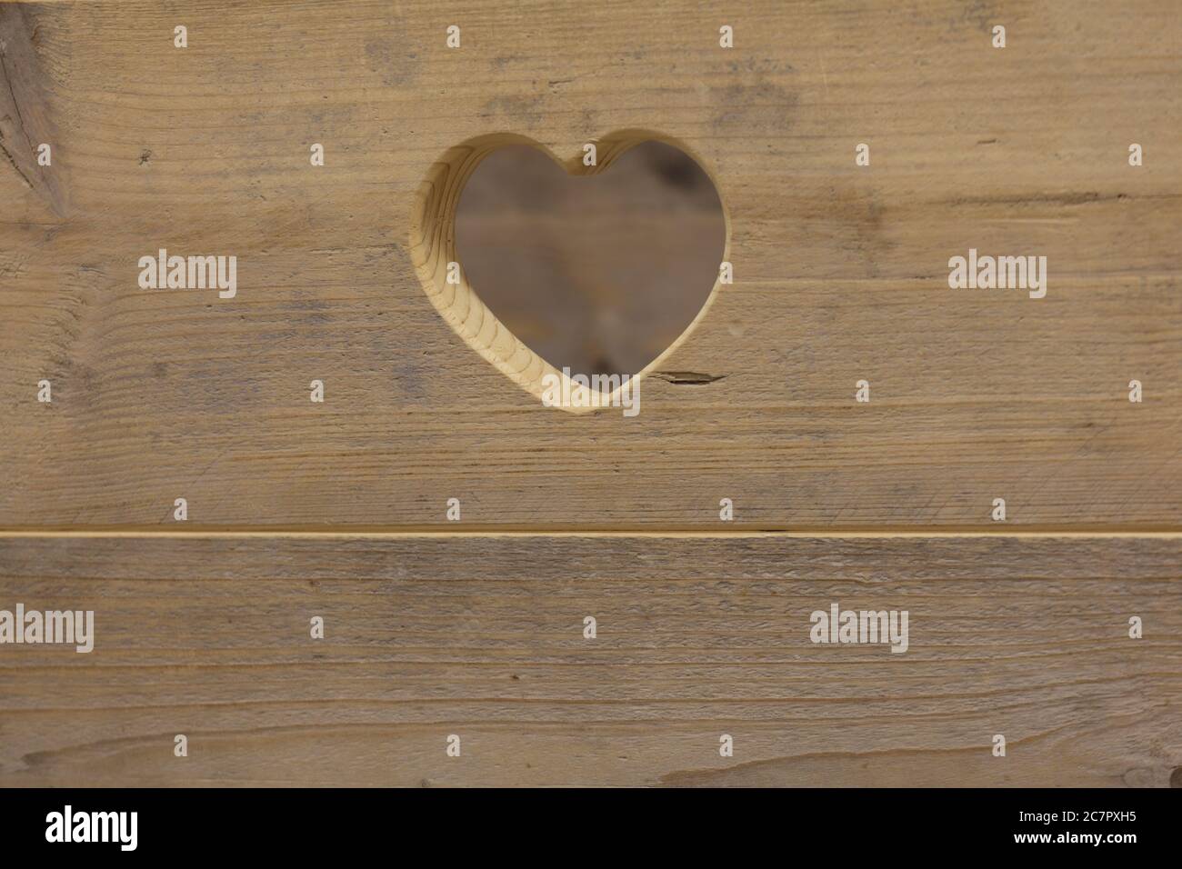 Herz in einer verbeteten Platte geschnitzt. Feine Holzbearbeitung Stockfoto