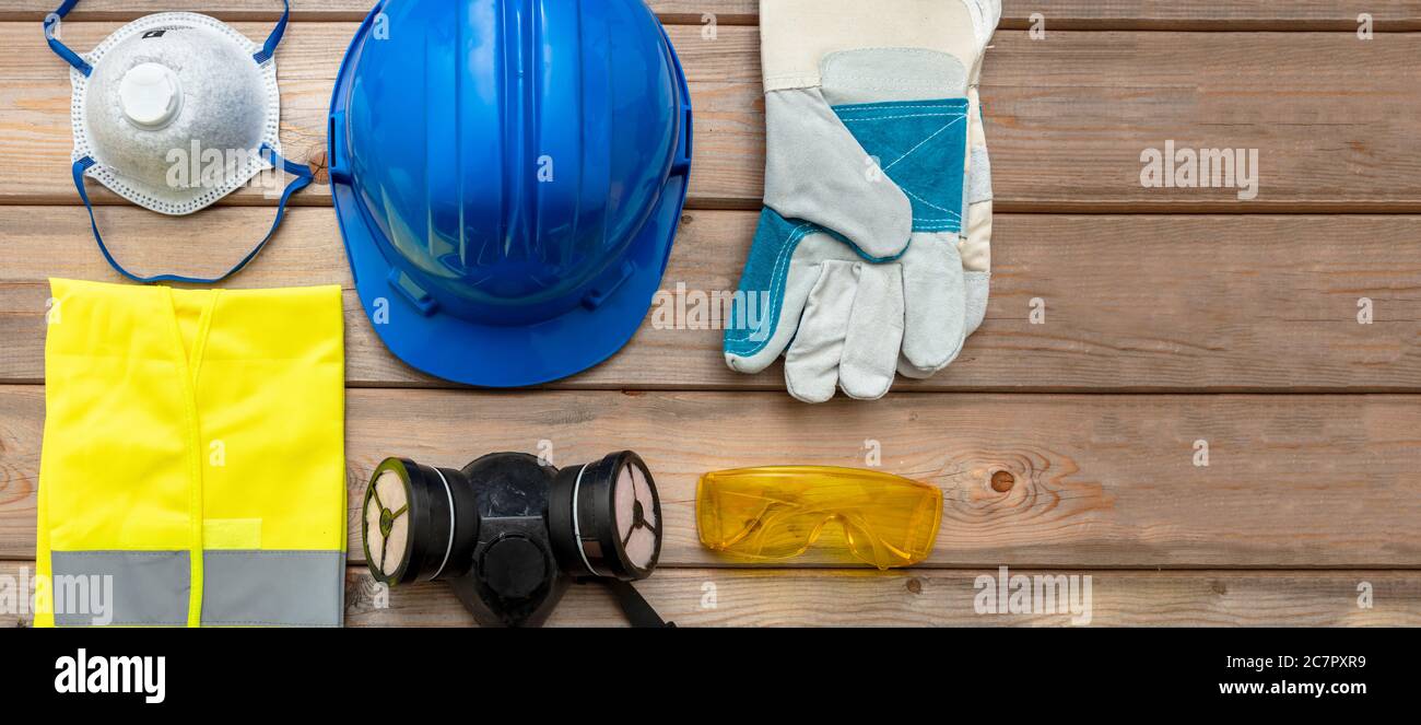 Arbeitsschutzausrüstung. Industrielle Schutzausrüstung auf Holzhintergrund. Baustellen-Gesundheits- und Sicherheitskonzept Stockfoto