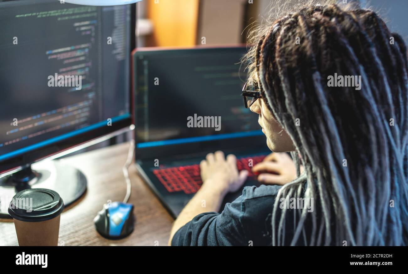 Moderne junge weibliche Programmierer ist das Schreiben von Programmcode auf einem Laptop zu Hause. Remote-Arbeit im IT-Bereich. Das Konzept der Softwareentwicklung. Stockfoto
