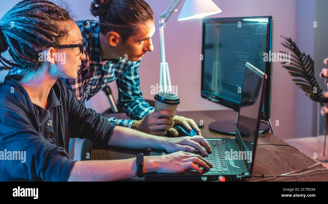 Programmierer entwickeln Software, indem sie mit Software-Code zusammen arbeiten. Teamarbeit. Moderne Arbeit eines IT-Ingenieurs. Stockfoto
