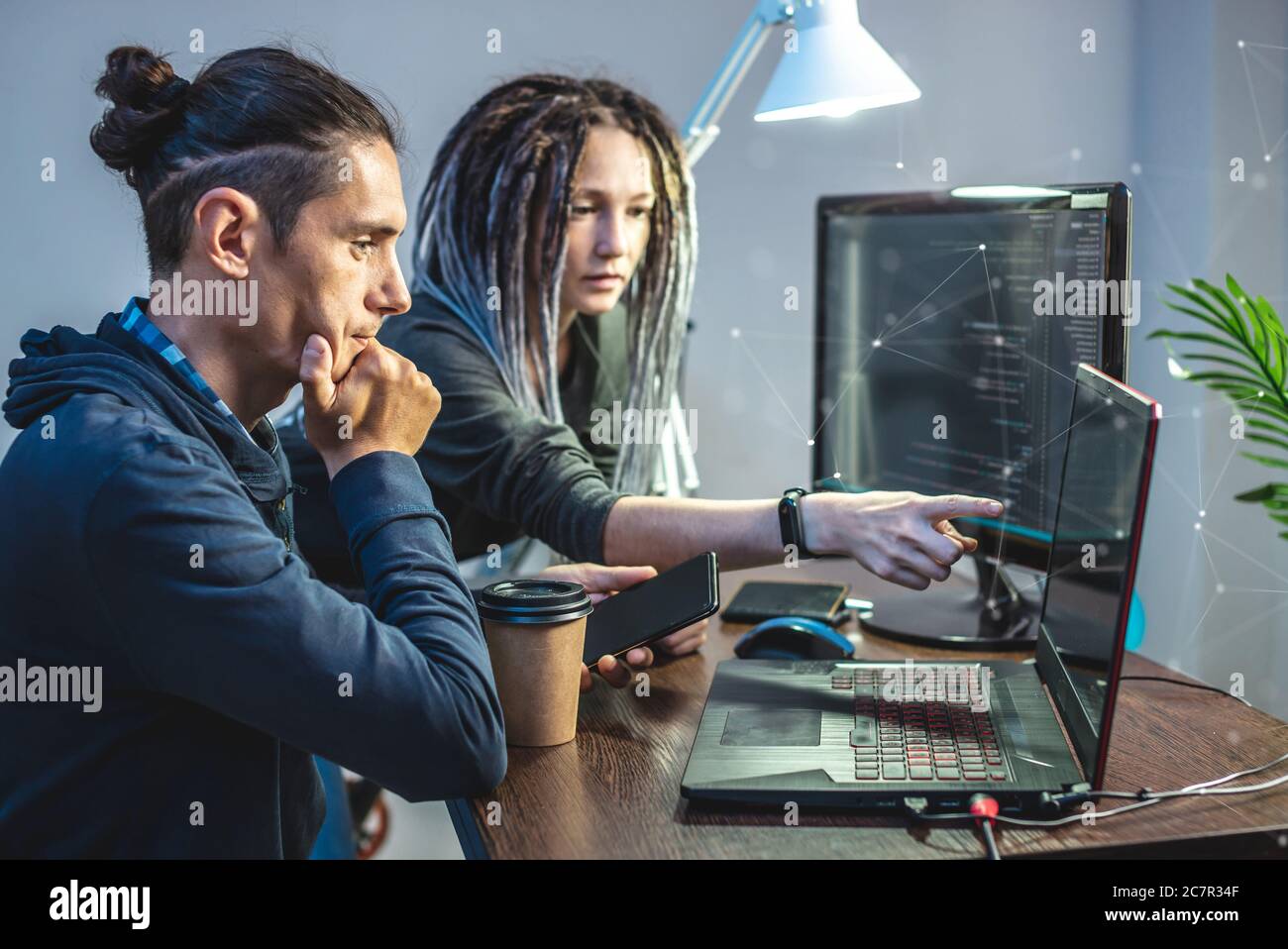 Programmierer entwickeln Software, indem sie mit Software-Code zusammen arbeiten. Teamarbeit. Moderne Arbeit eines IT-Ingenieurs. Stockfoto