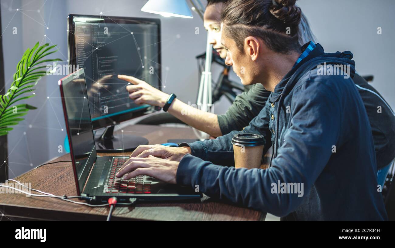 Programmierer entwickeln Software, indem sie mit Software-Code zusammen arbeiten. Teamarbeit. Moderne Arbeit eines IT-Ingenieurs. Stockfoto