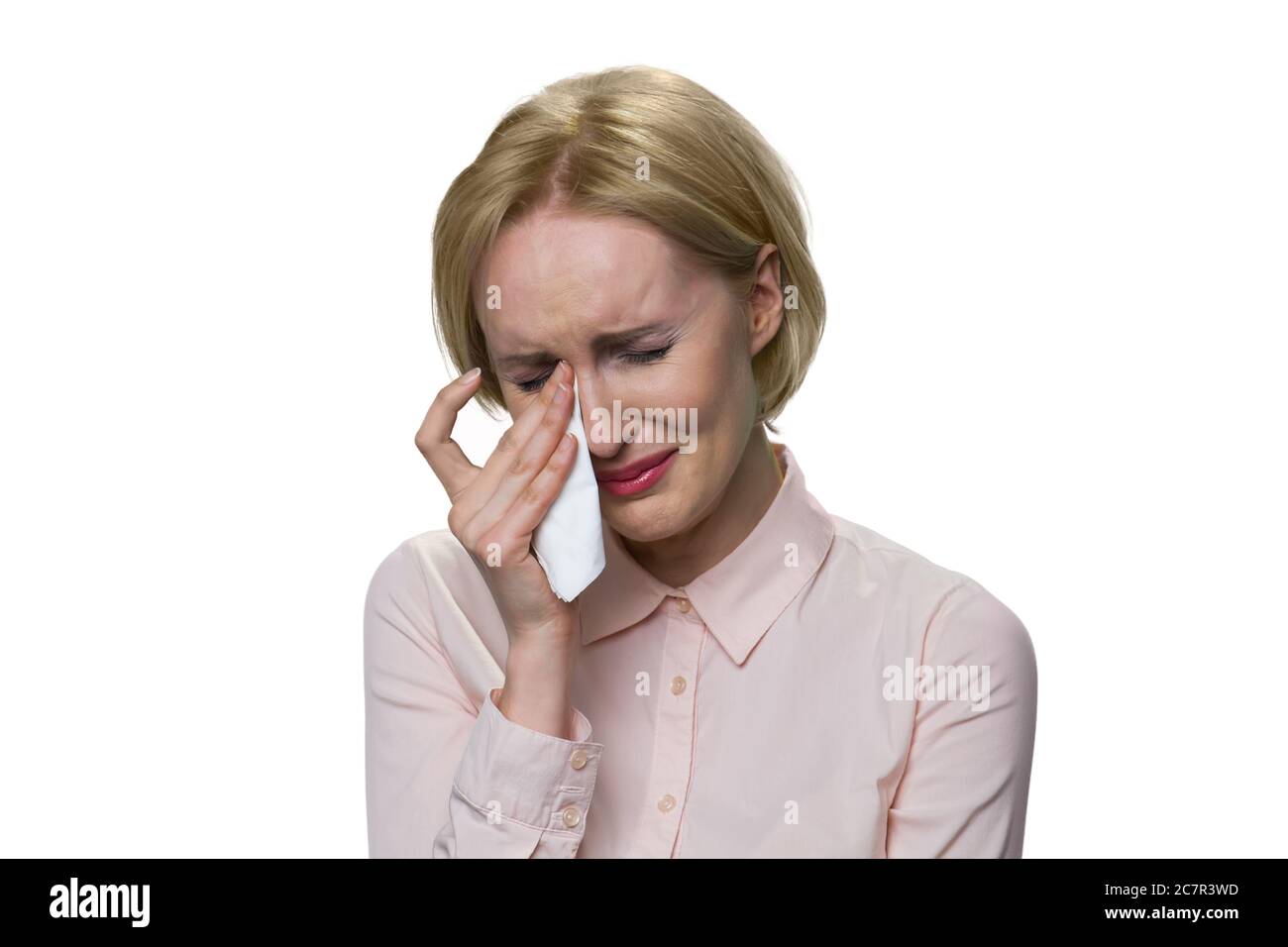 Traurige blonde Frau weint auf weißem Hintergrund. Stockfoto