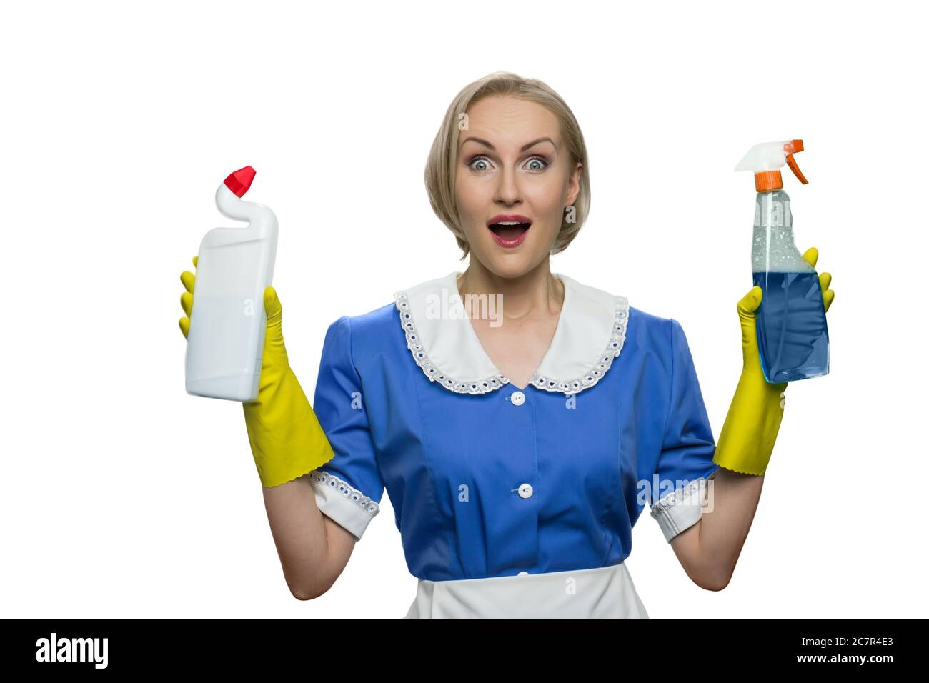 Überrascht wurde das Zimmermädchen mit offenem Mund, der Reinigungsspray und Toilettendesinfektionsmittel auf weißem Hintergrund hält. Stockfoto