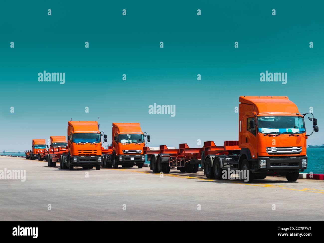 Flotte von Lastwagen und Anhänger warten auf Container am Hafen zu holen. Containertransport und Logistik, Spedition und Lieferung. Stockfoto