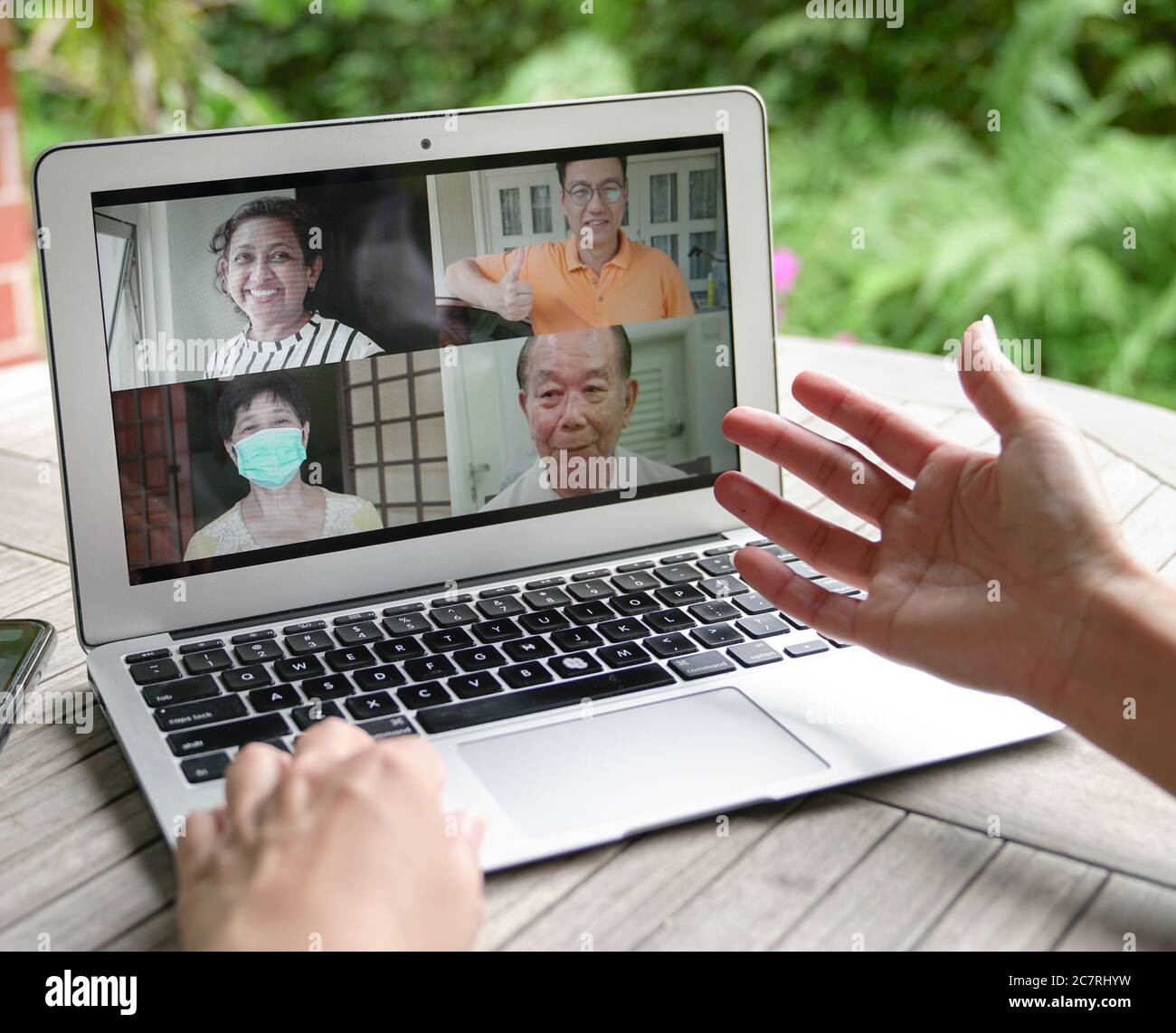 Frau mit Videoanruf und Chat mit Familie über Computer Laptop zu Hause mit Blick auf den Garten Stockfoto