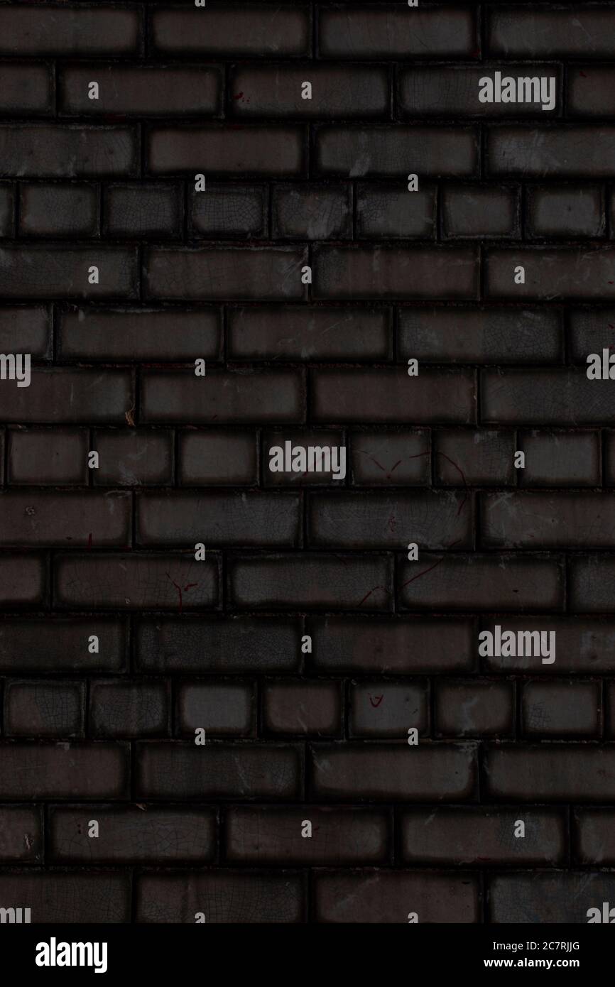 Schlichte schwarze Backsteinwand Hintergrund Stockfoto