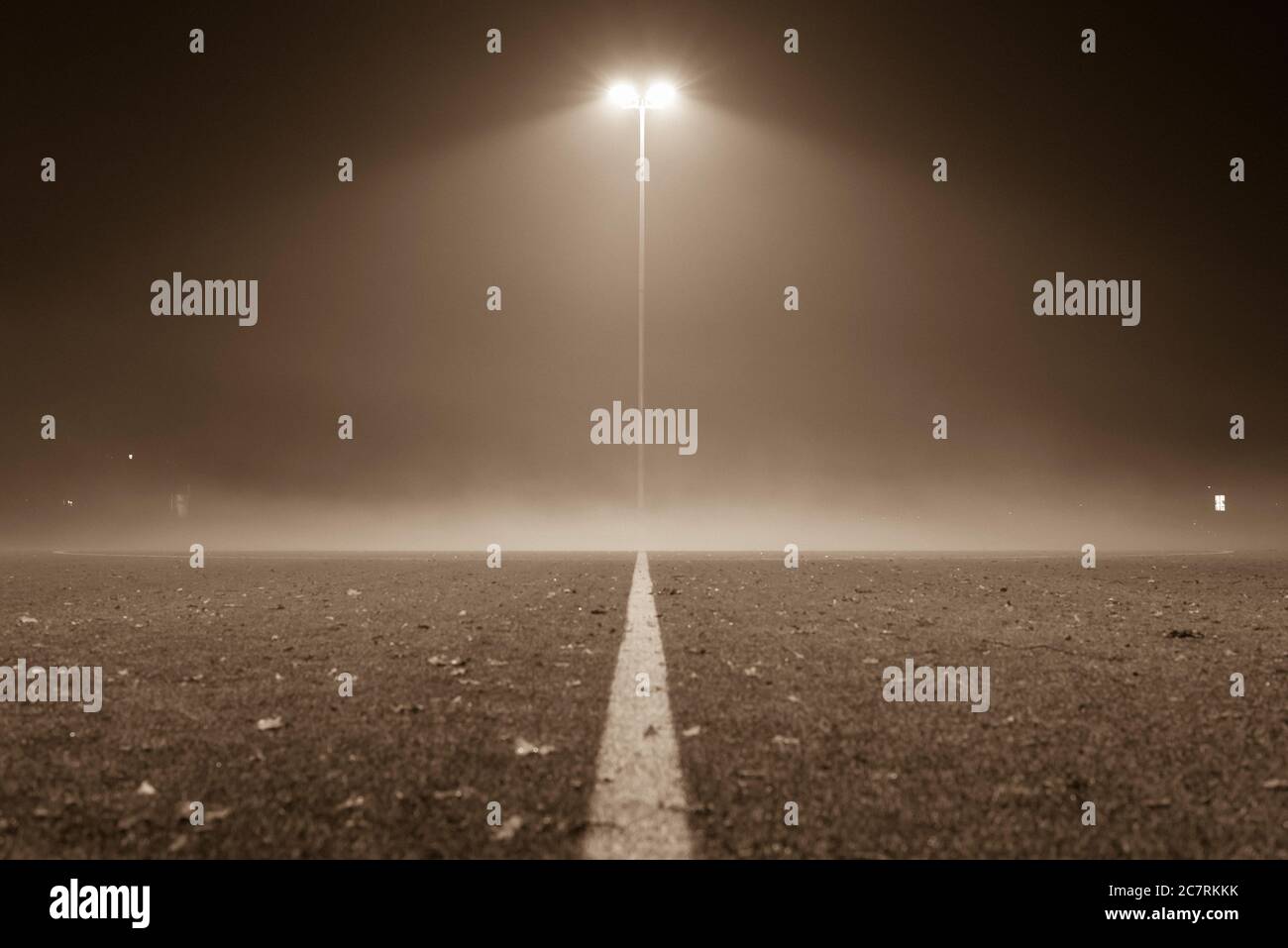 Nebliger Fußballplatz, Fußball, Fußballplatz bei Nacht mit Nebel, Laterne und Nebel, schwarz-weiß Foto Stockfoto