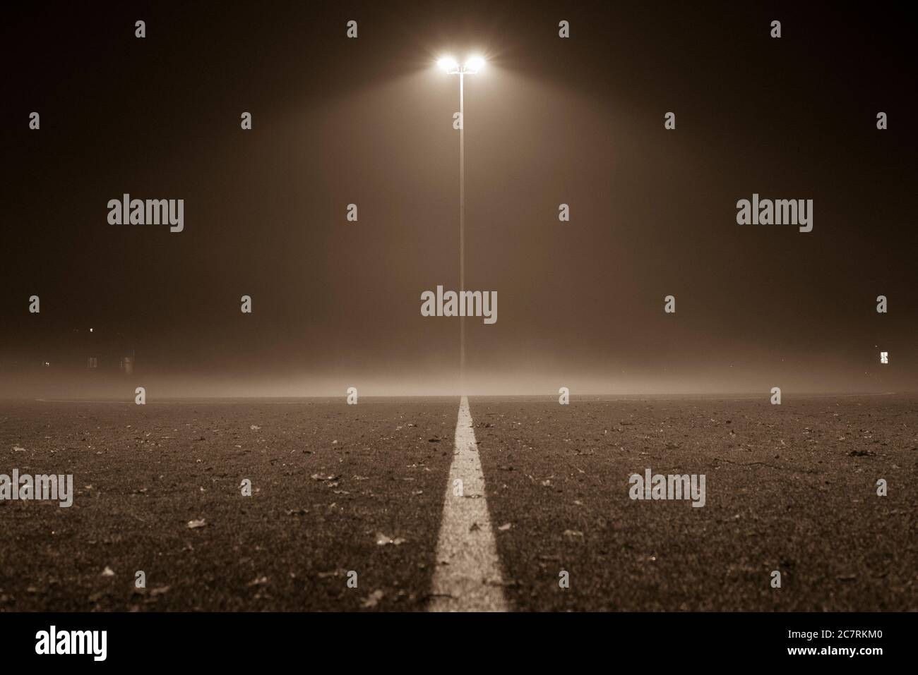 Nebliger Fußballplatz, Fußball, Fußballplatz bei Nacht mit Nebel, Laterne und Nebel, schwarz-weiß Foto Stockfoto