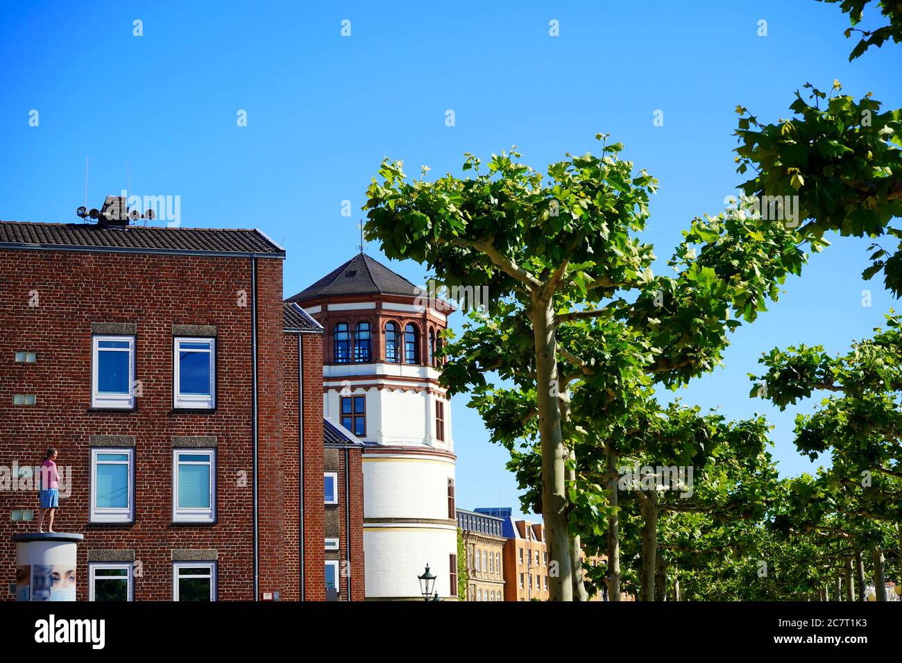 Idyllischer Blick auf die Rheinpromenade mit einer modernen Skulptur auf einer Werbungssäule (Kunstwerk von Christoph Pöggeler) und dem antiken Schifffahrtsmuseum. Stockfoto