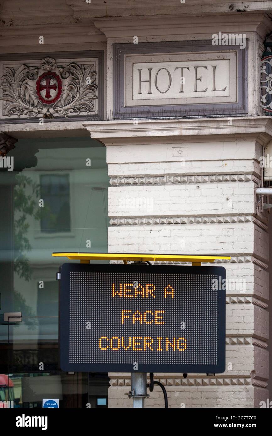 Elektronisches Schild, außerhalb Charing Cross U-Bahnstation, das lautet ‘TRAGEN SIE EINE GESICHTSBEDECKUNG’. London, England Stockfoto