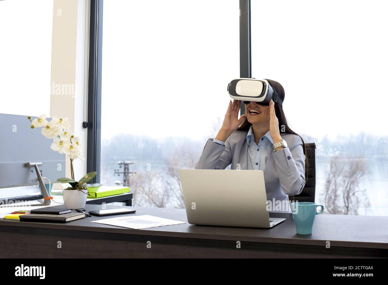 Geschäftsfrau in einem VR-Headset genießen virtuelle Projektpräsentation bei Das Büro Stockfoto