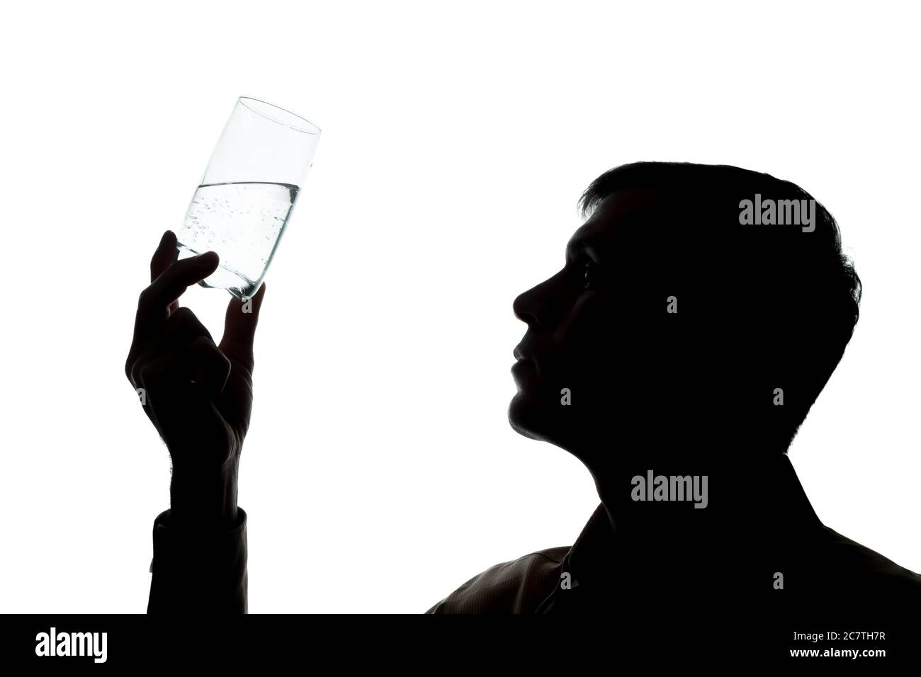 Junger Mann trinkt ein Glas Sekt, überprüft die Qualität - Silhouette Stockfoto