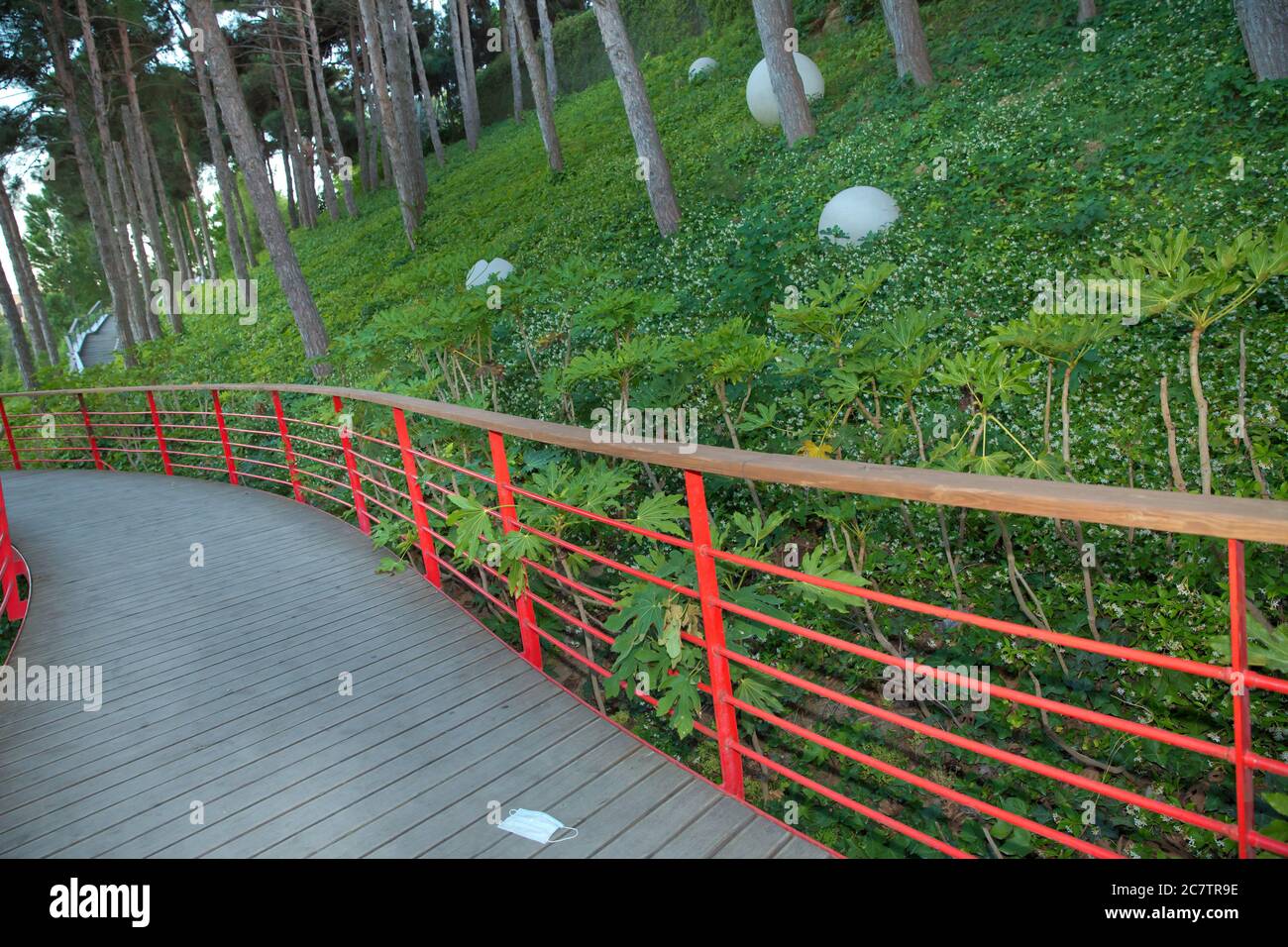 Rote Brücke außerhalb des Nationalparks. Green Leaf Park. Es gibt weiße runde Lichter auf dem Boden. Brückenstraße im Park . Stockfoto