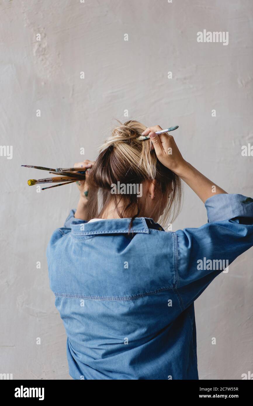 Frau macht Frisur mit Pinsel malen. Rückansicht. Stockfoto