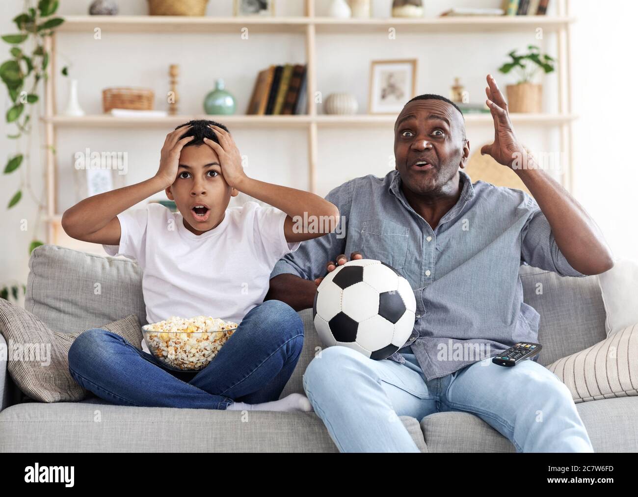 Tor Verloren. Enttäuscht Black Großvater und sein Enkel Fußball im Fernsehen Stockfoto