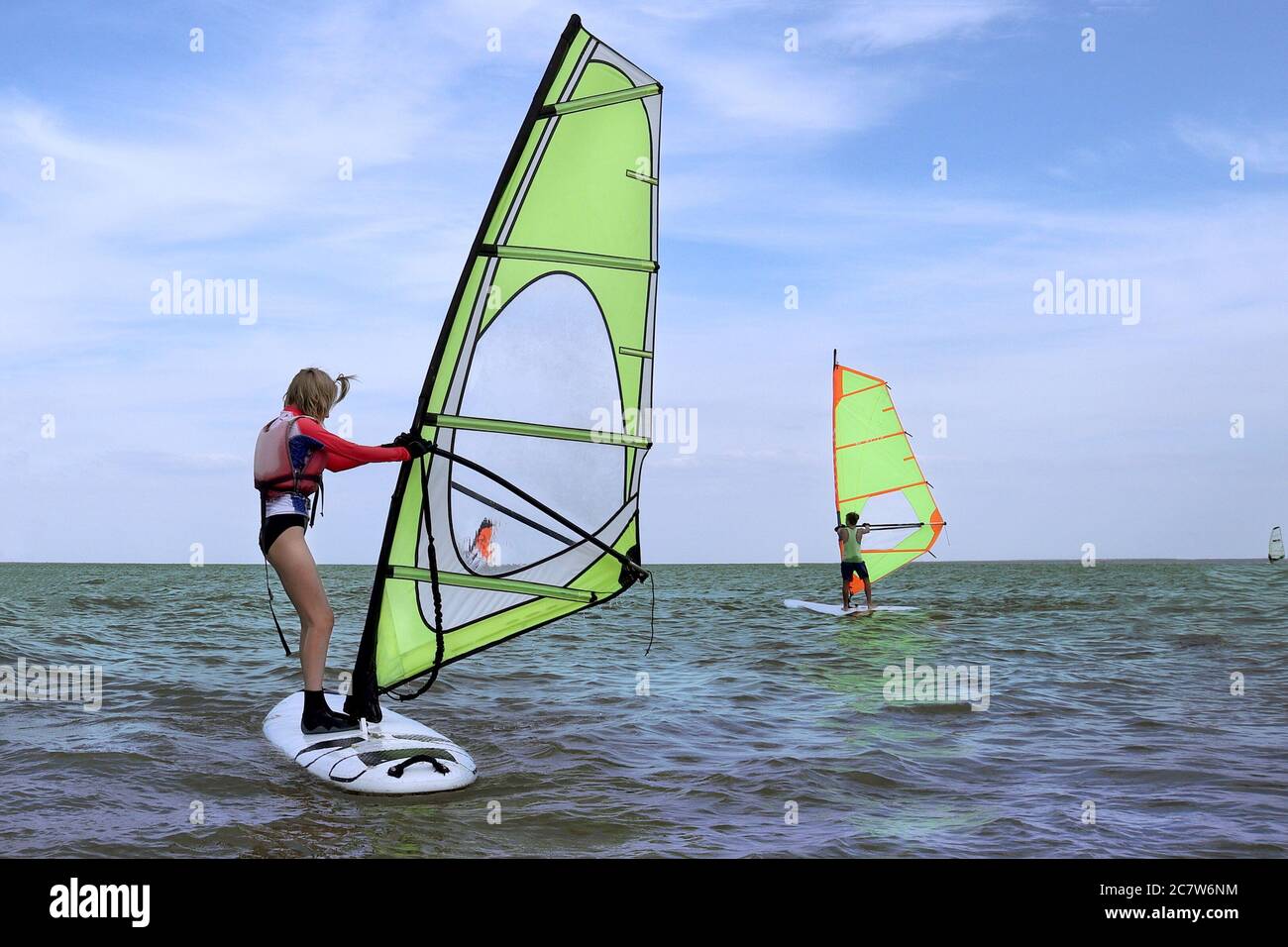 Teenager-Mädchen Übung im Windsurfen Wassersport auf dem Meer Stockfoto