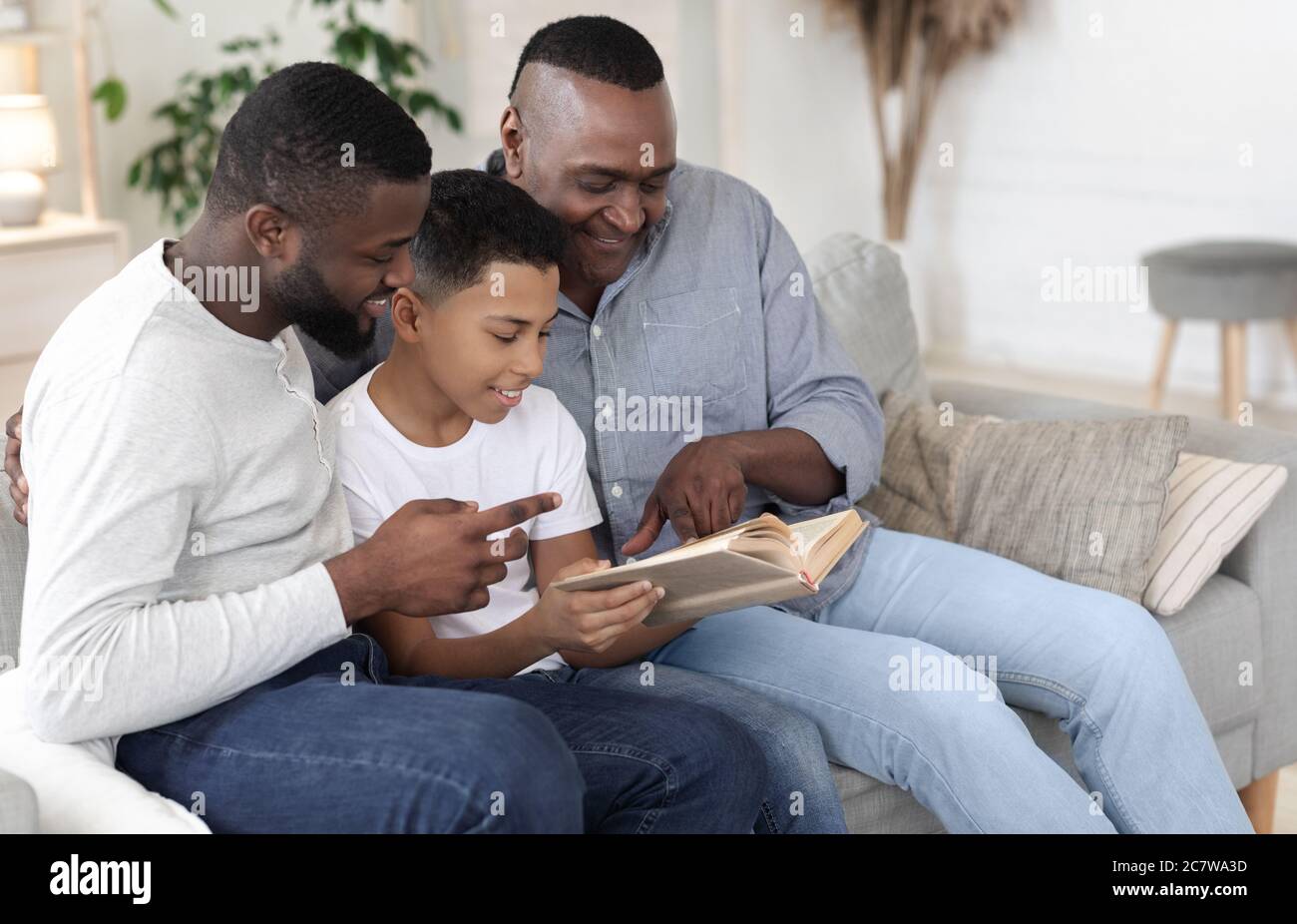 Familienvertreib. Happy African Boy Lesebuch Mit Papa Und Großvater Zusammen Stockfoto