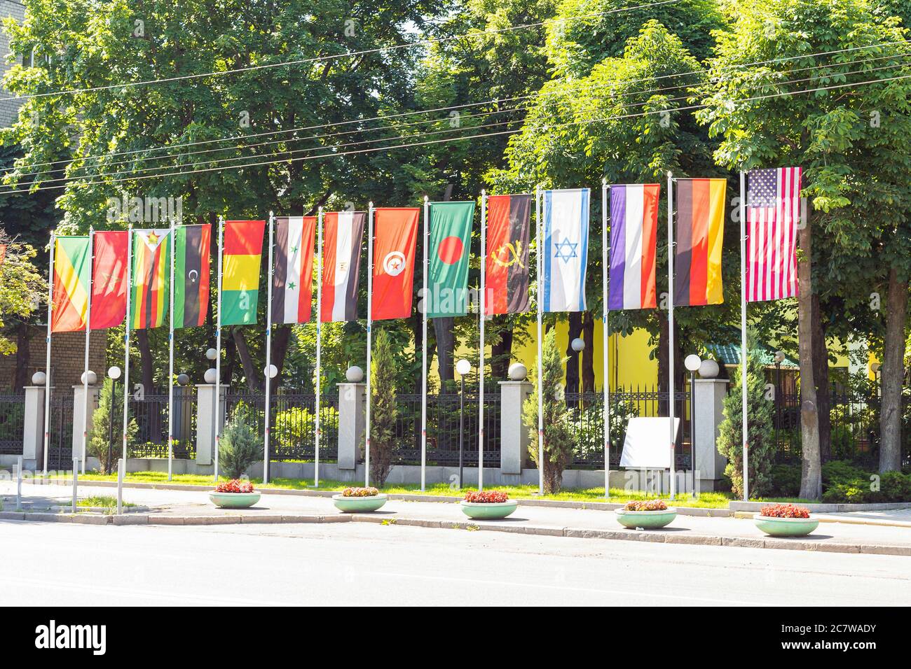 Staatsflaggen verschiedener Länder auf Fahnenmast in einer Reihe winken im Wind. Diplomatie Konzept, internationale Beziehungen Stockfoto