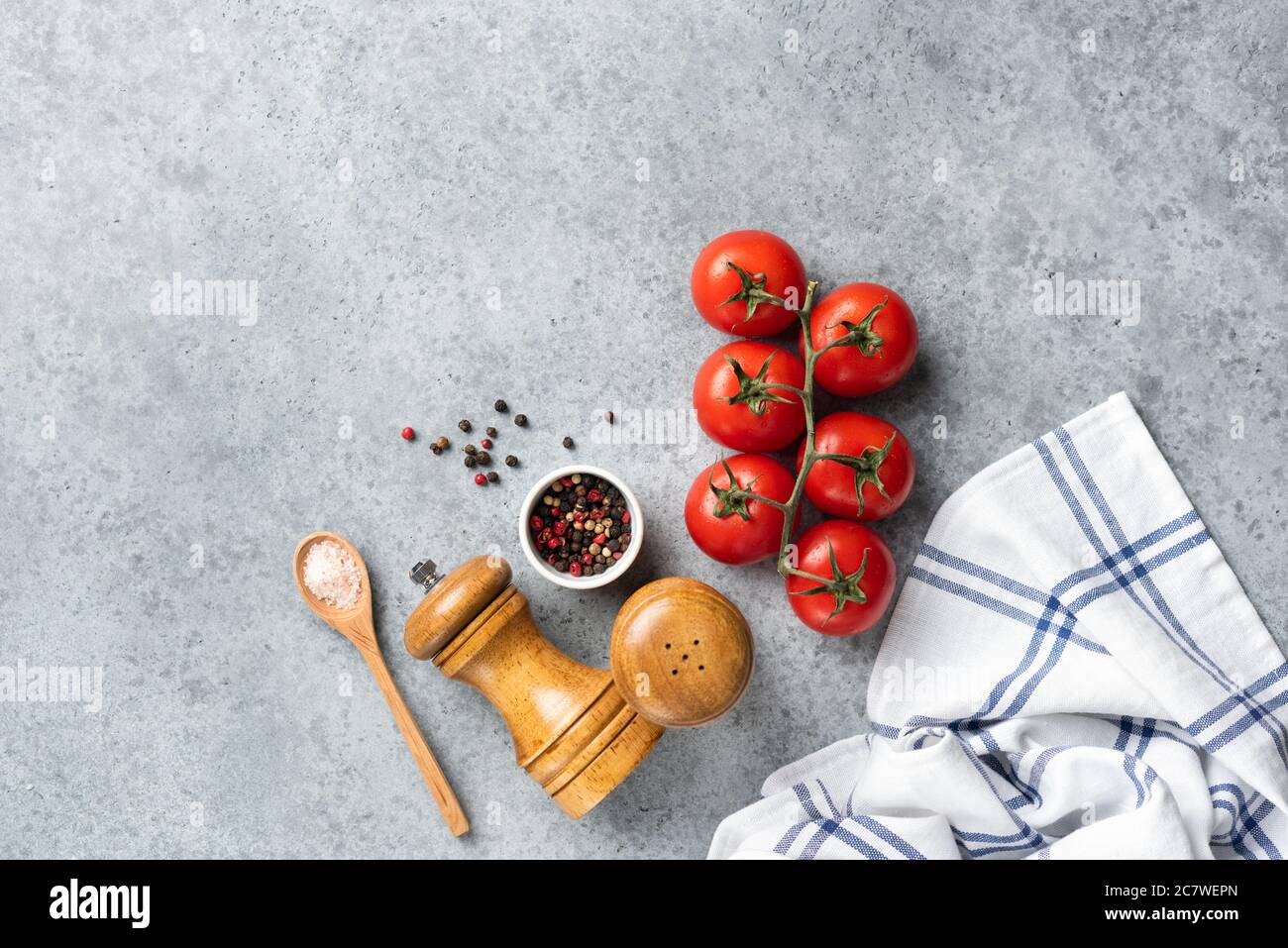 Tomaten und Gewürze zum Kochen auf grauem Betongrund. Frische Zutaten für die Küche. Rezept, Hintergrund, Menü-Konzept Stockfoto