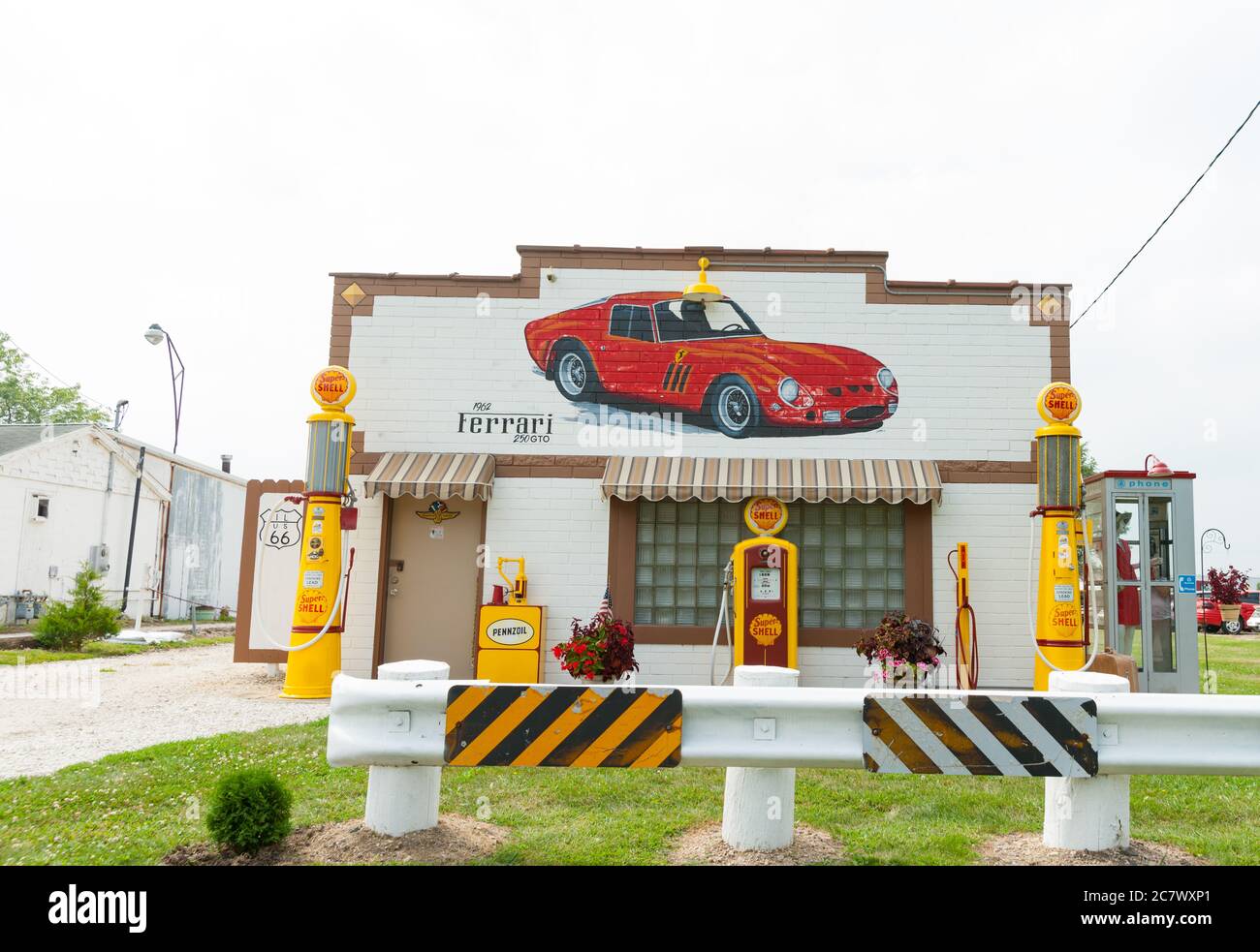 Route 66 USA - August 31 2015; Old Shell Garage entlang der Route 66 mit Farrari 250 GT an der Fassade und ikonischen gelben Kraftstoffpumpen. Stockfoto