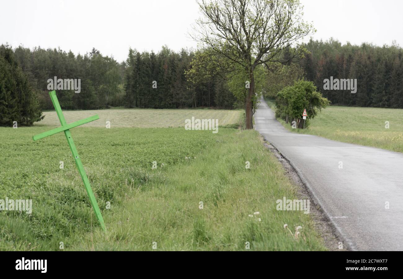 Grünes Kreuz auf der Seite der Straße Stockfoto