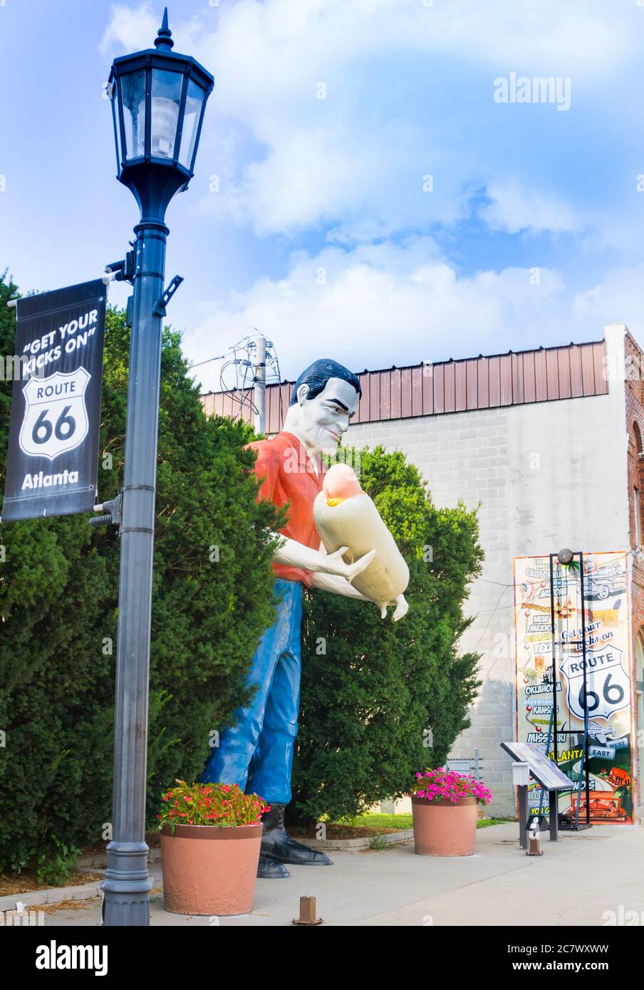 Atlanta USA August 31 2015; Statue Bunyon Muffler Mann hält gaint Hotdog in Atlanta, Illinois, USA, neben Schild Holen Sie sich Ihre Kicks auf Route 66. Stockfoto