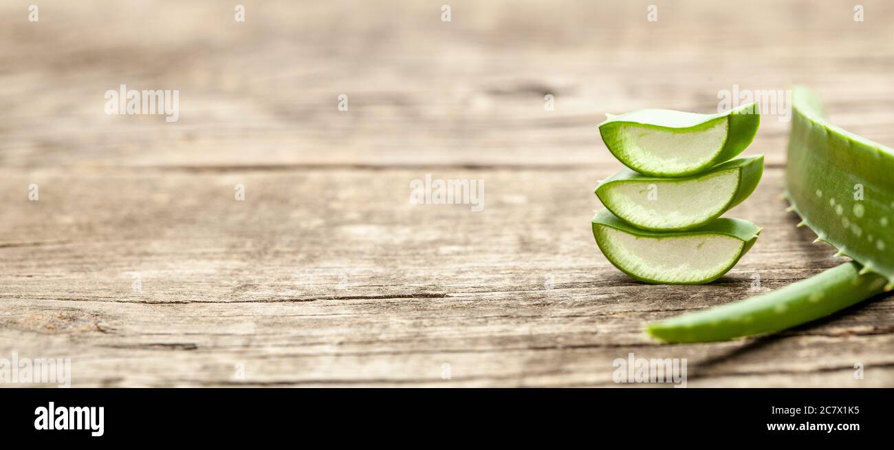 Stücke Aloe Vera mit Fruchtfleisch auf einem hölzernen Hintergrund. Stockfoto