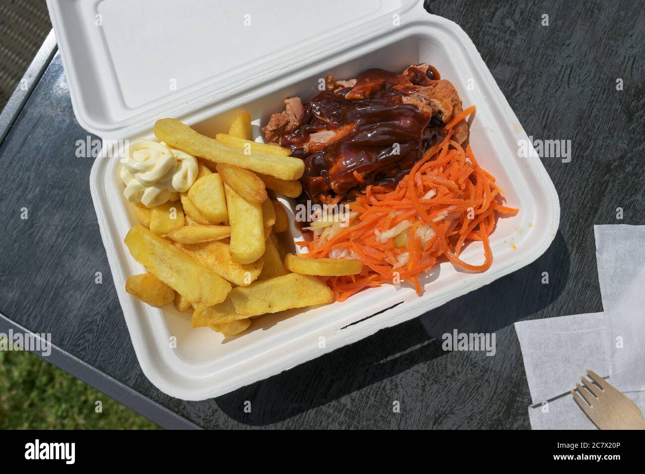 Fastfood in einer Box mit Schweinefleisch, Krautsalat und Karotten-Salat, pommes Frites, Grillsauce und Mayonnaise, Blick von oben, Stockfoto